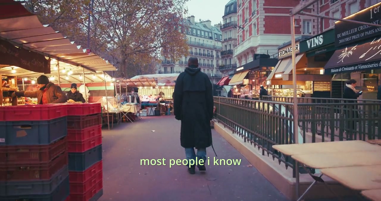 Founders Film source moment at 01:19, a person walking through a Paris market